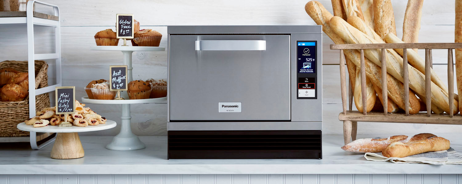 Panasonic high-speed commercial oven sits on a cafe countertop surrounded by pastries and fresh baked bread