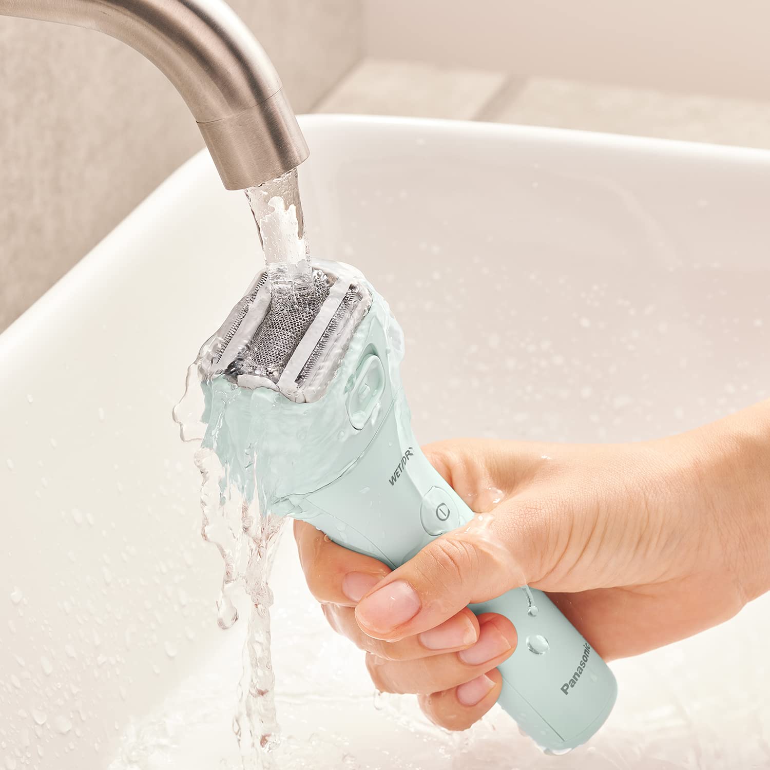 3-Blade Women's Electric Shaver (ES-WL60-G) being rinsed under water for easy cleaning.
