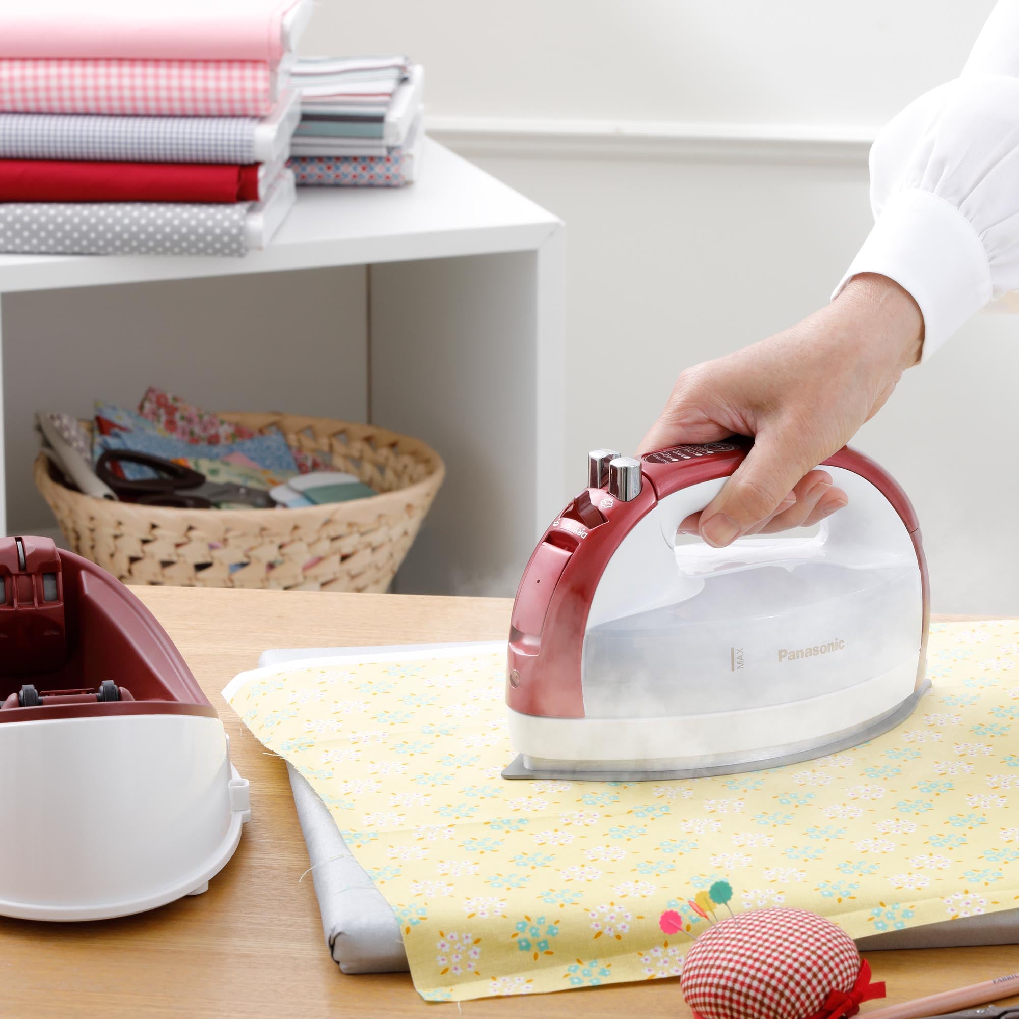 Quilting with Cordless Steam/Dry Iron NI-QL2000, 1700W Wide Stainless Plate, using powerful steam on a yellow fabric in a sewing room.